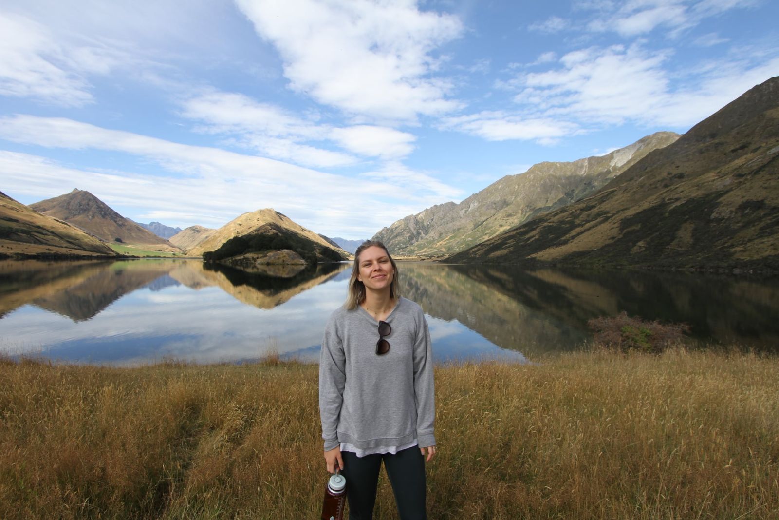 Abby standing in front of a lake with mountain backdrop