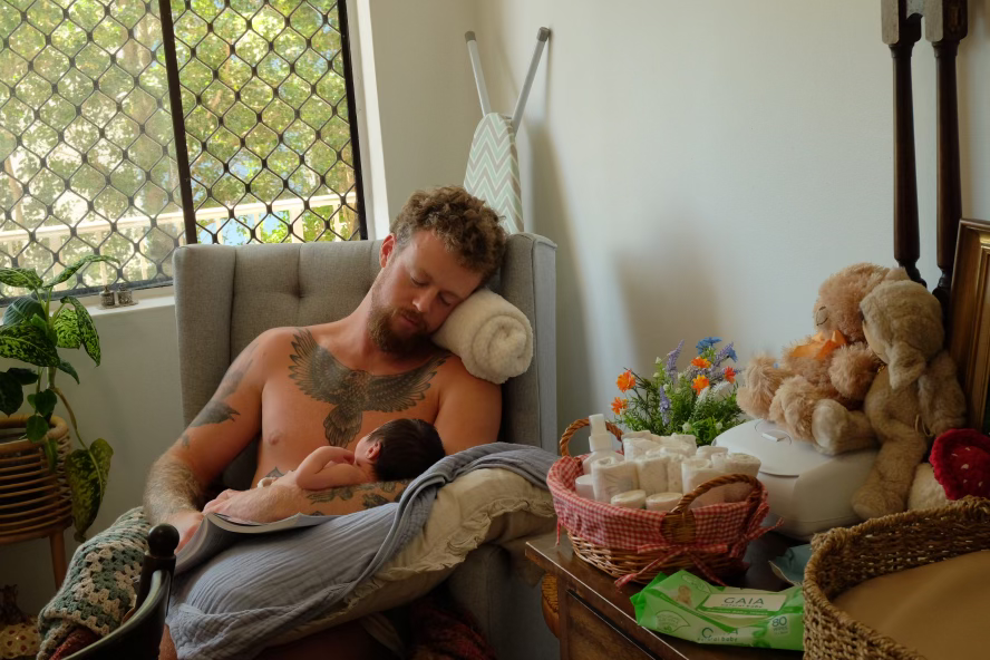 Adam asleep in a chair with his son