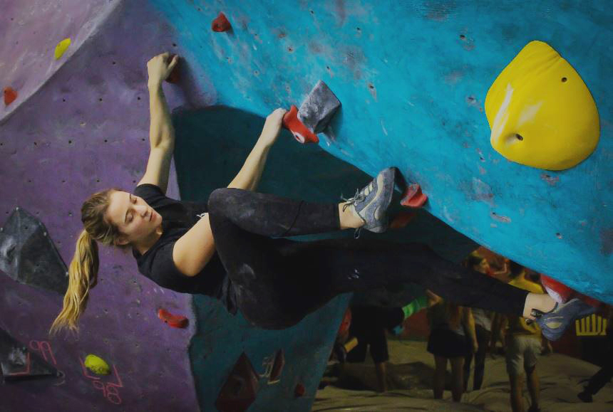 Person climbing overhang in bouldering gym