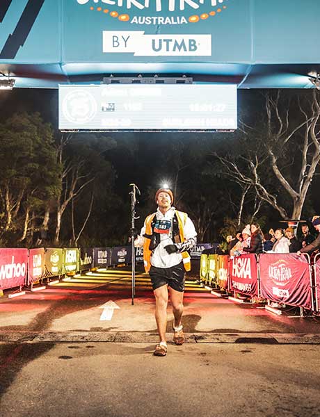 Adam Green wearing Salomon Bonatti waterproof jacket at race finish line.