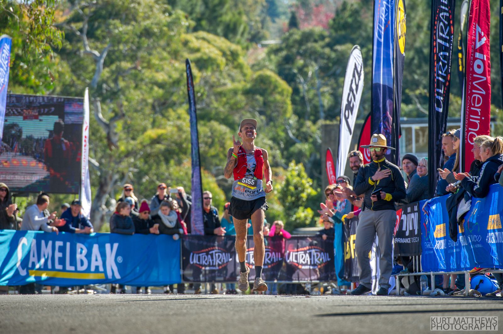 Anderson running in an ultra-marathon wearing a grey Wild Earth racing shirt