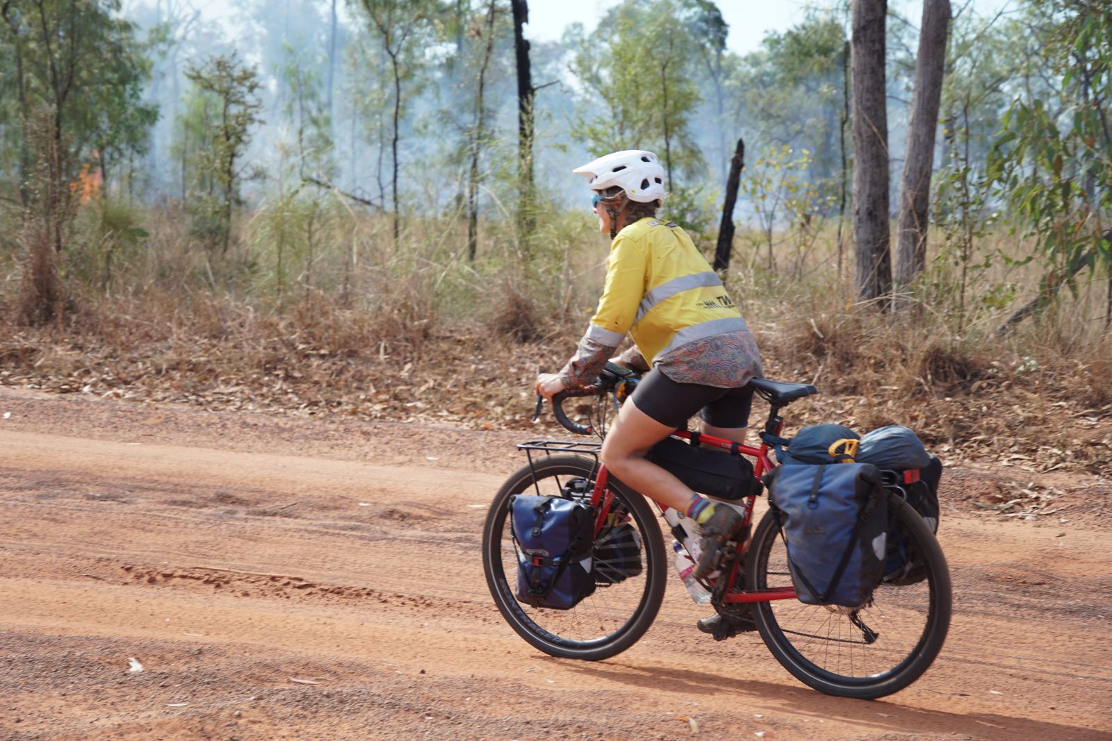 Person riding a bike with bike panniers featured