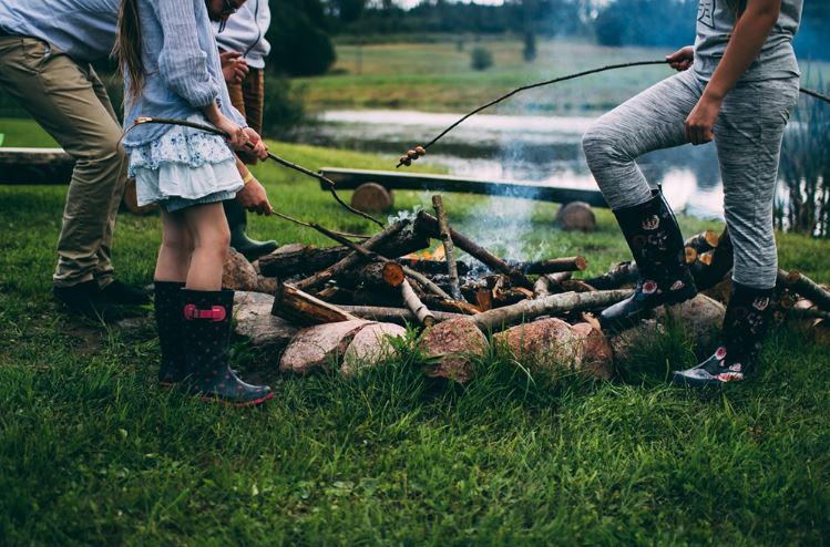 Family standing around campfire