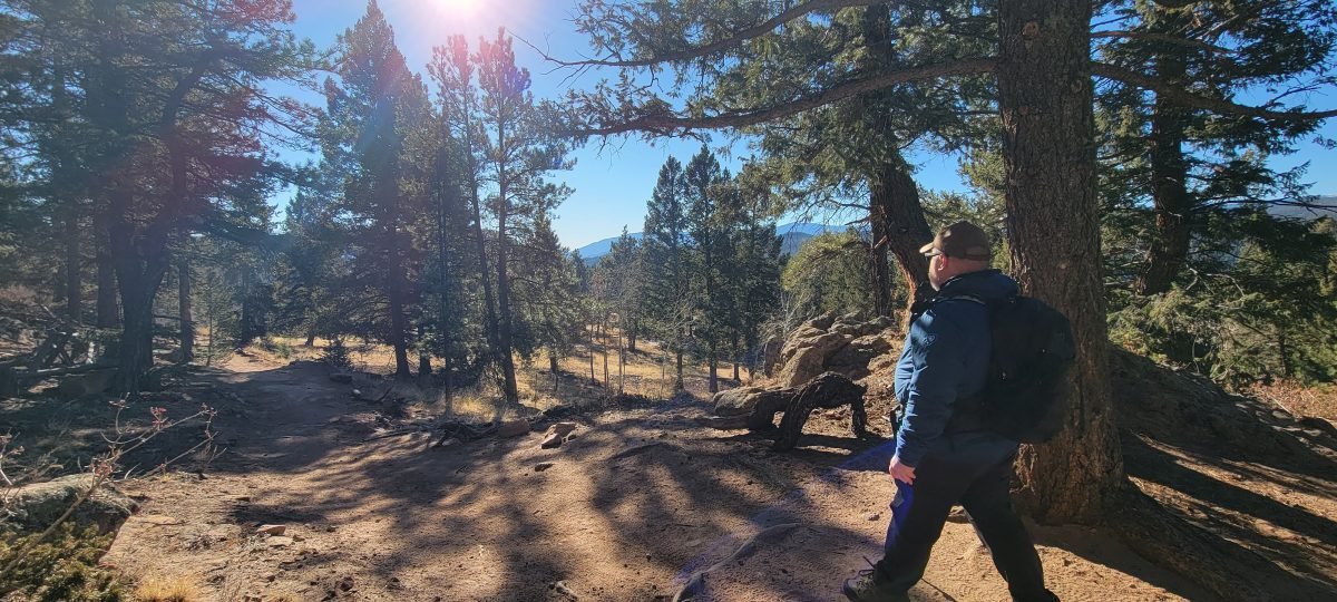 A man hiking through a forest on a dirt trail