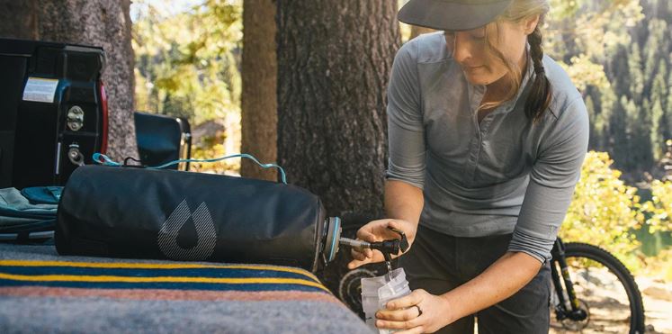 Woman filling her water bottle with water storage container