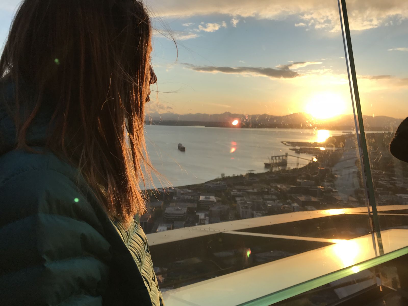Jess wearing the Patagonia Down Hoody looking out over a city at sunset