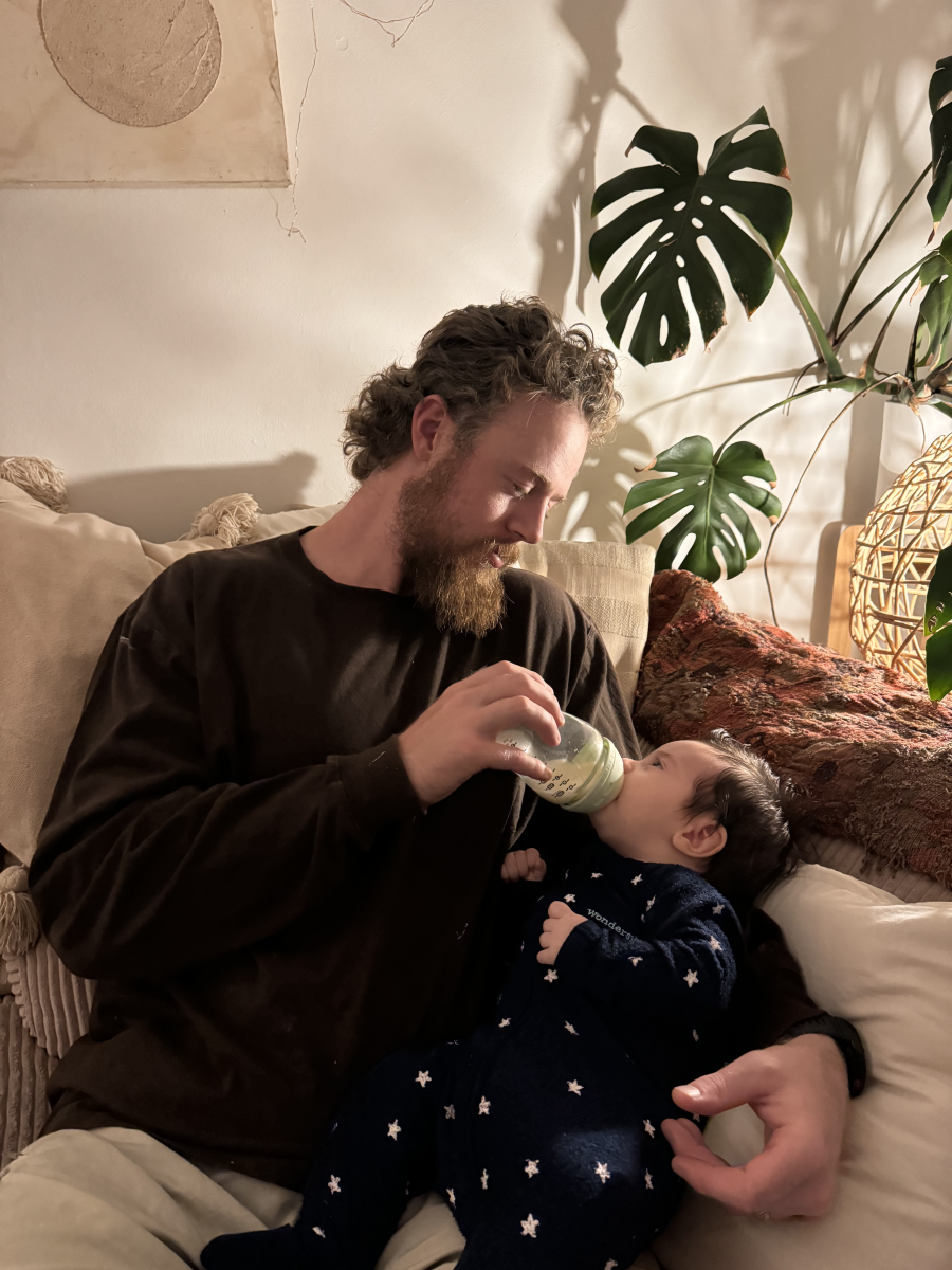 Adam feeding his son with a bottle