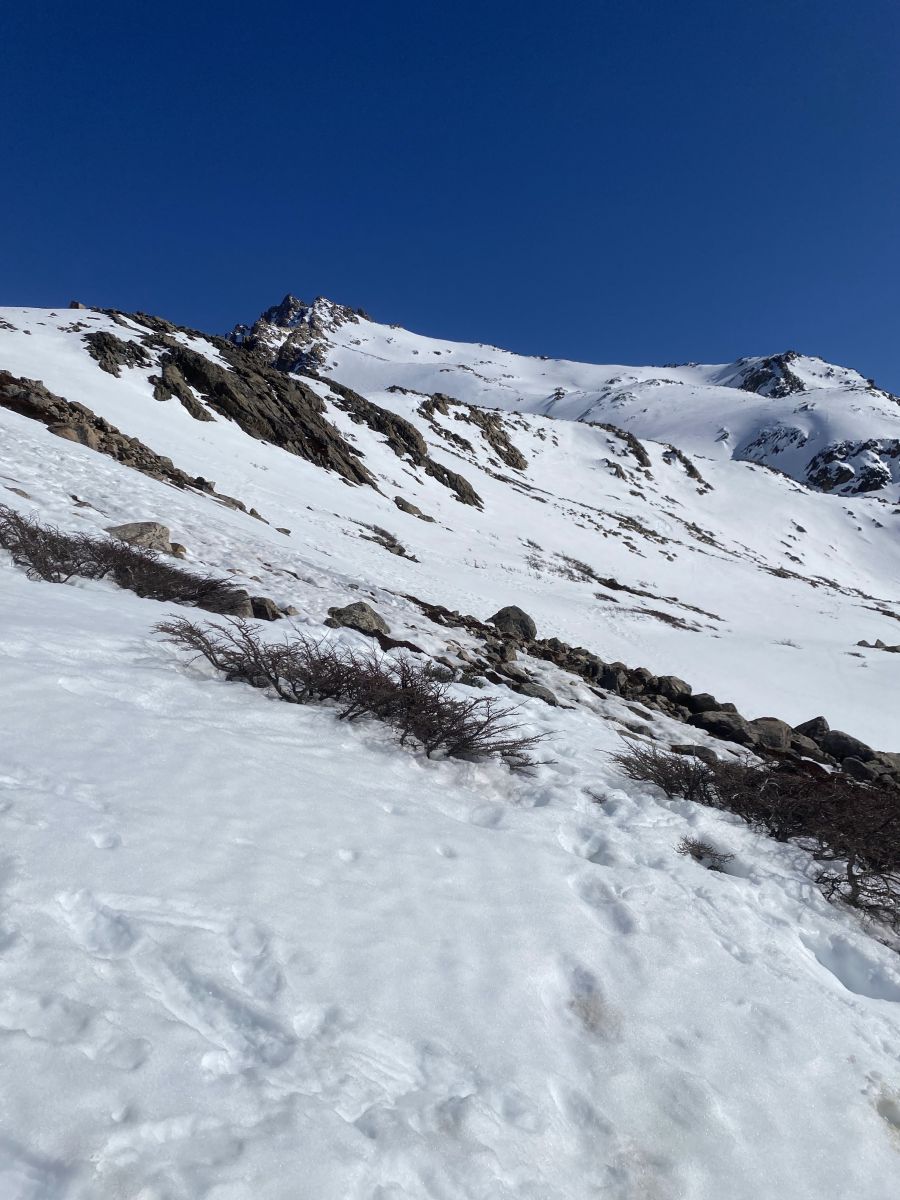 Approaching the summit of Laguna Los Tres with a snowy alpine landscape.