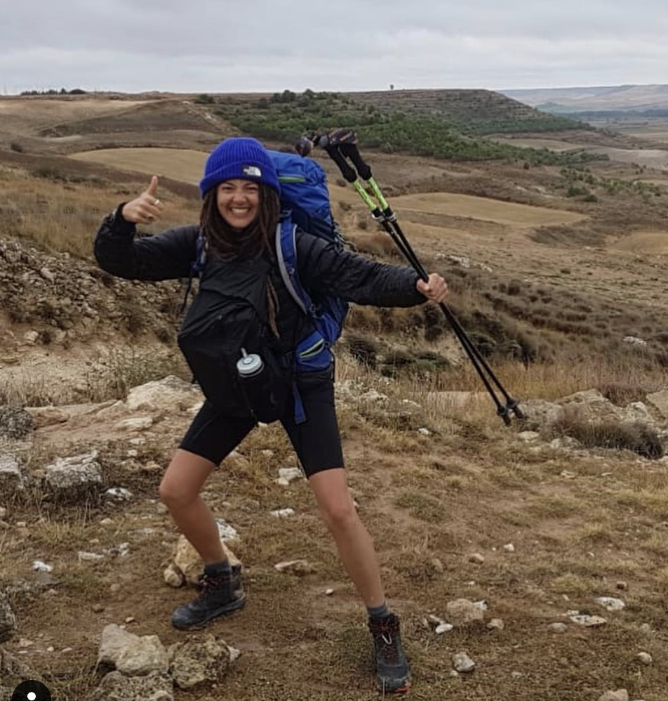 Lauren - young woman hiking with a hiking pack and poles