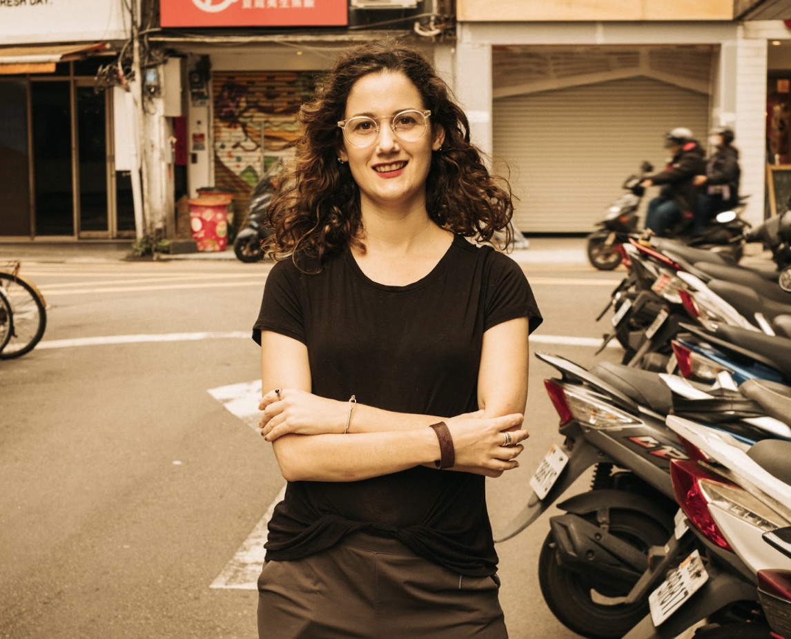 Nicola standing in the streets of Taipei with scooters in the background.