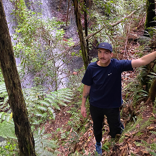 Rob Marrinon in the Australian rainforest standing in front of a waterfall