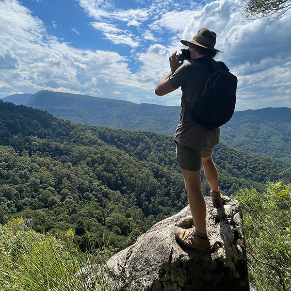 Ronan at the summit of a hike taking a photo