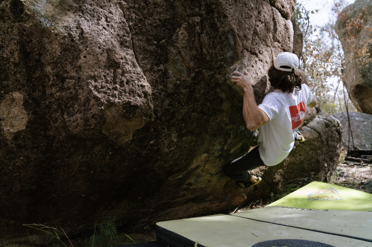 Man bouldering in The North Face t-shirt.