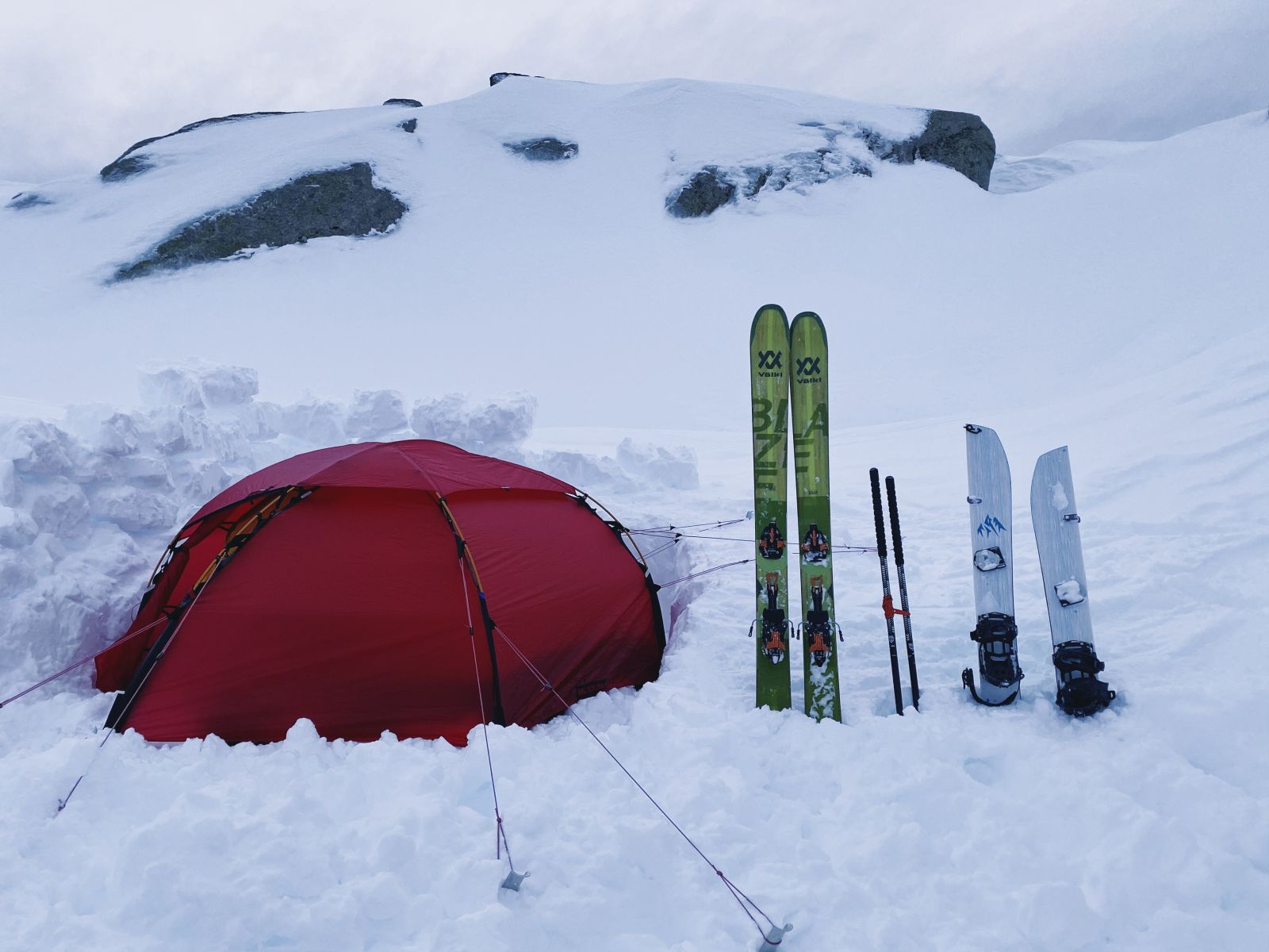 Red Hilleberg tent camping in the snow with skis and touring equipment