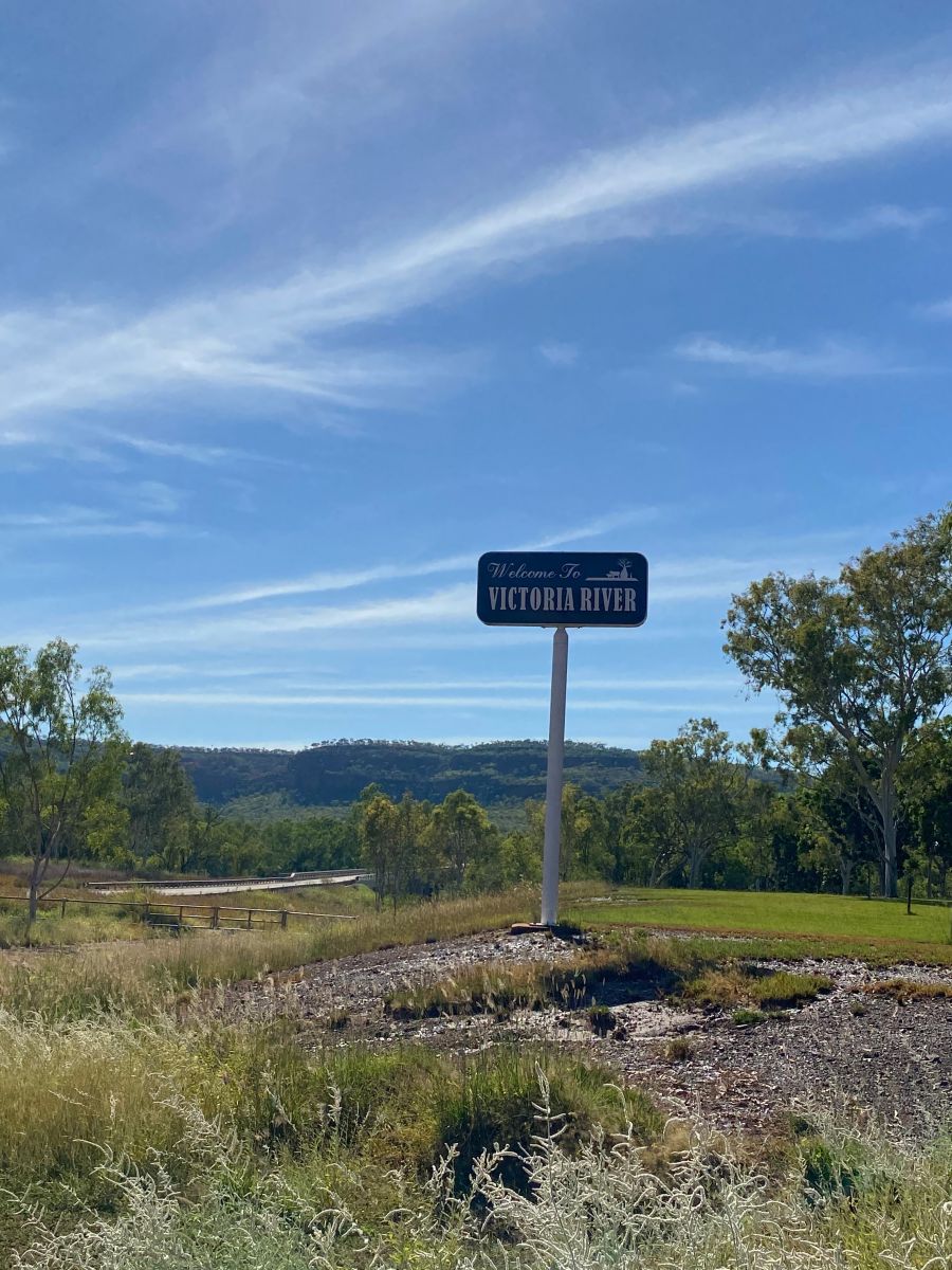 Blue sign that says 'Victoria River' in parkland