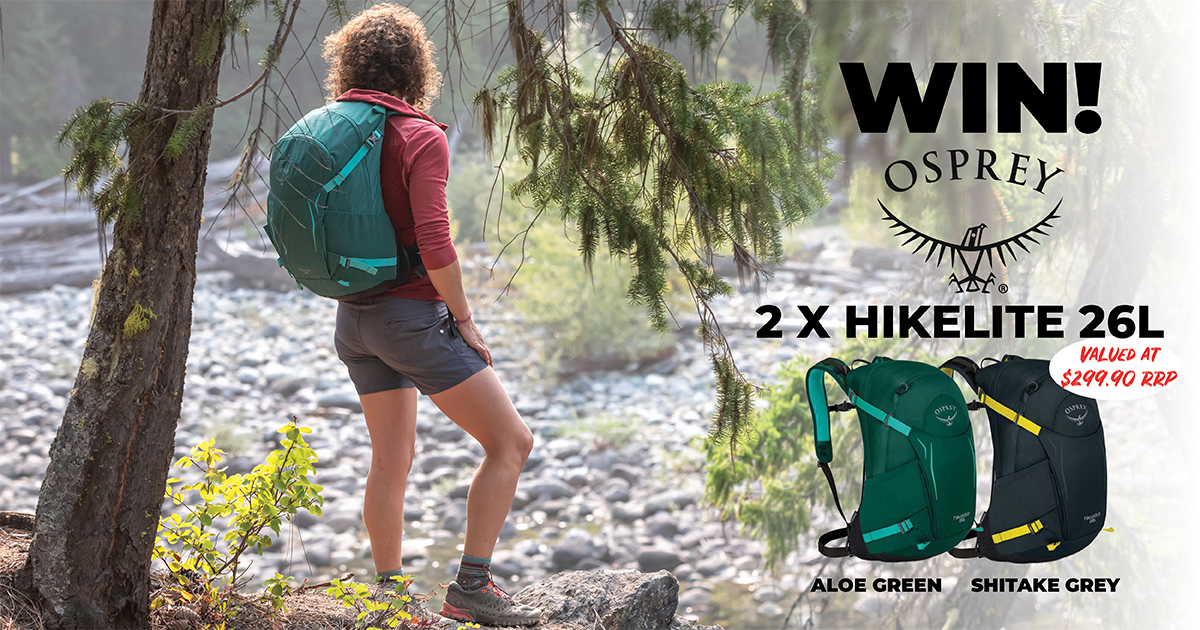 Osprey Competition - Win 2 x Hikelite 26L packs - Woman standing in the forest wearing Blue Osprey Hikelite pack