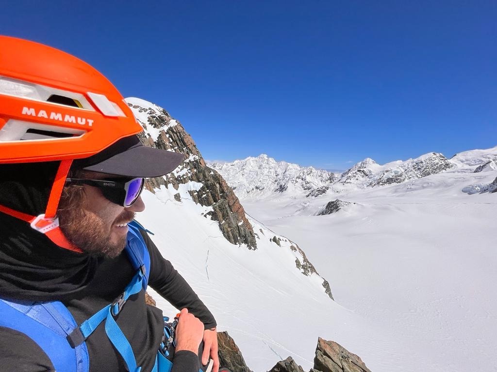 Aaron Shanks on top of a mountain with the Garmin InReach Mini 2