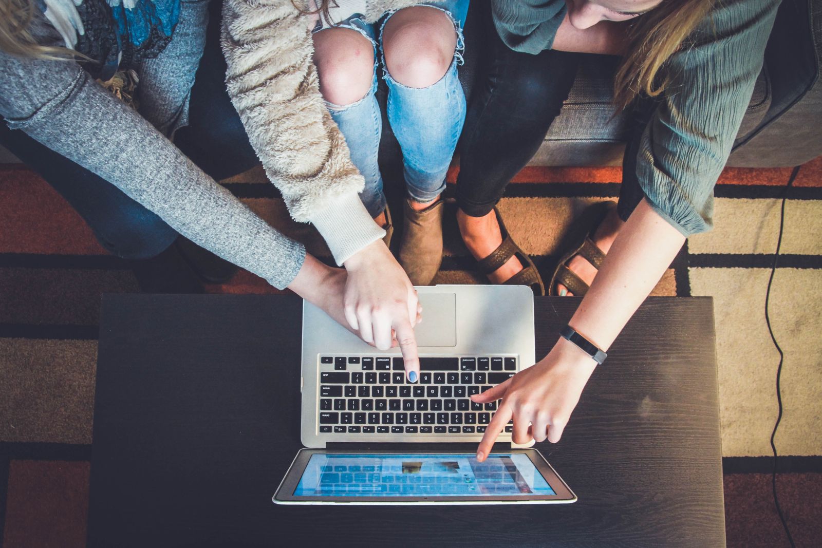 Friends looking at sales on a laptop