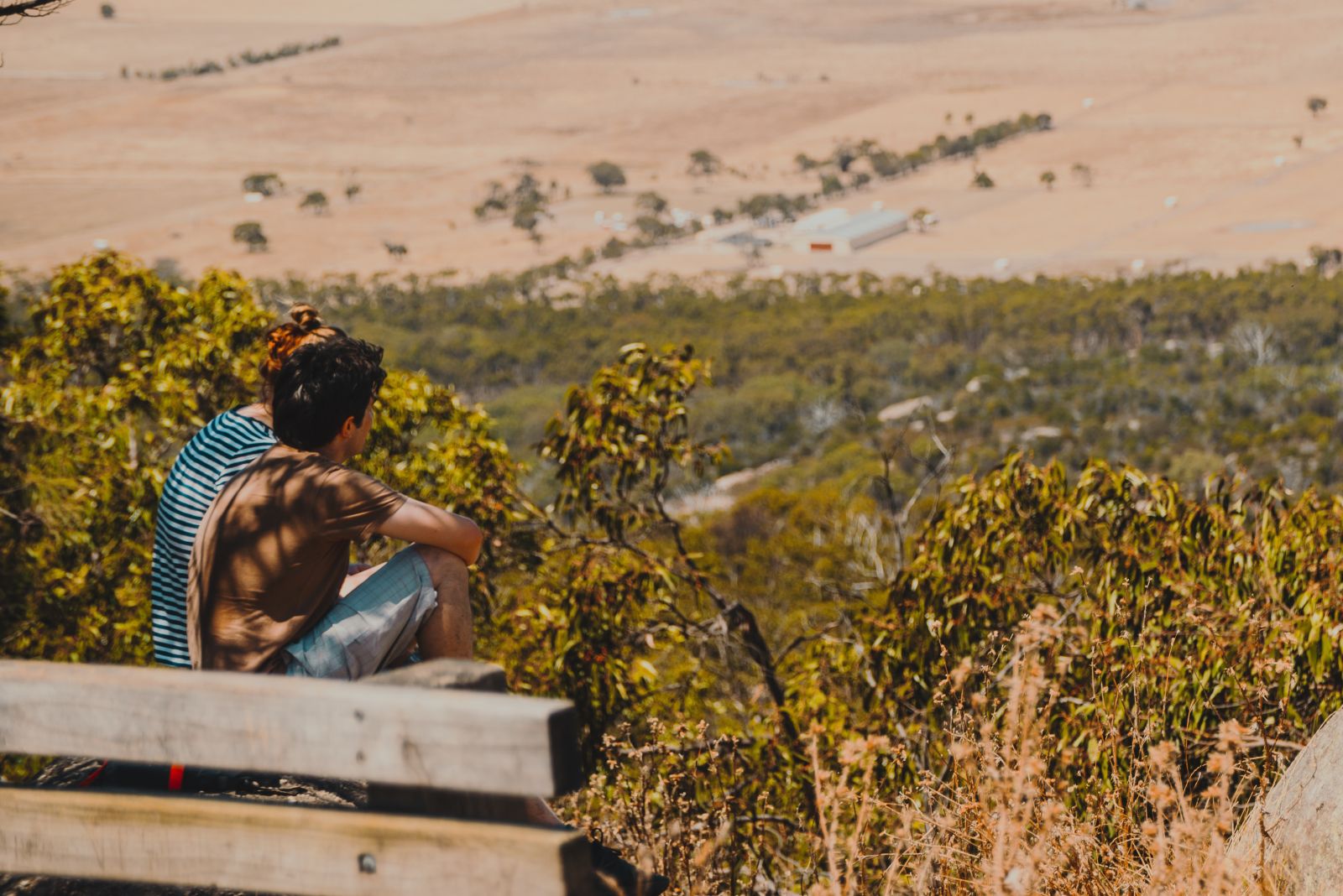 Teenagers sitting at a lookout with a view of Australian bushland