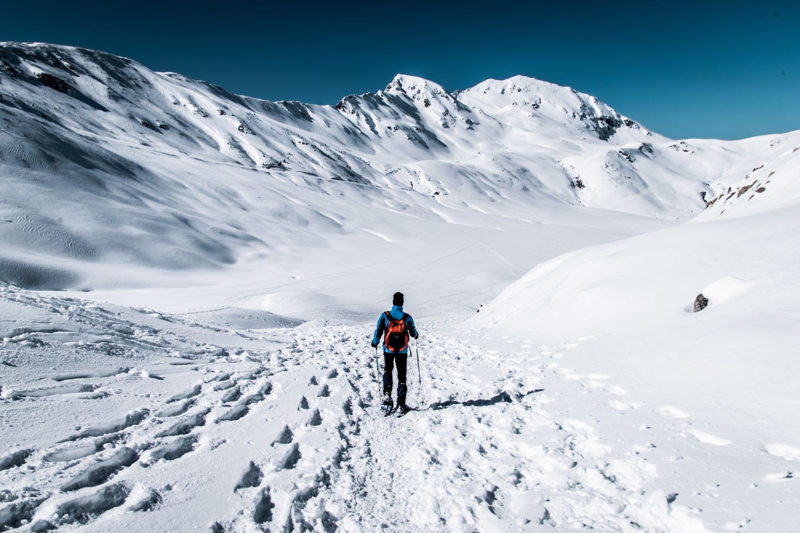 Person snowshoeing in snowy mountains 