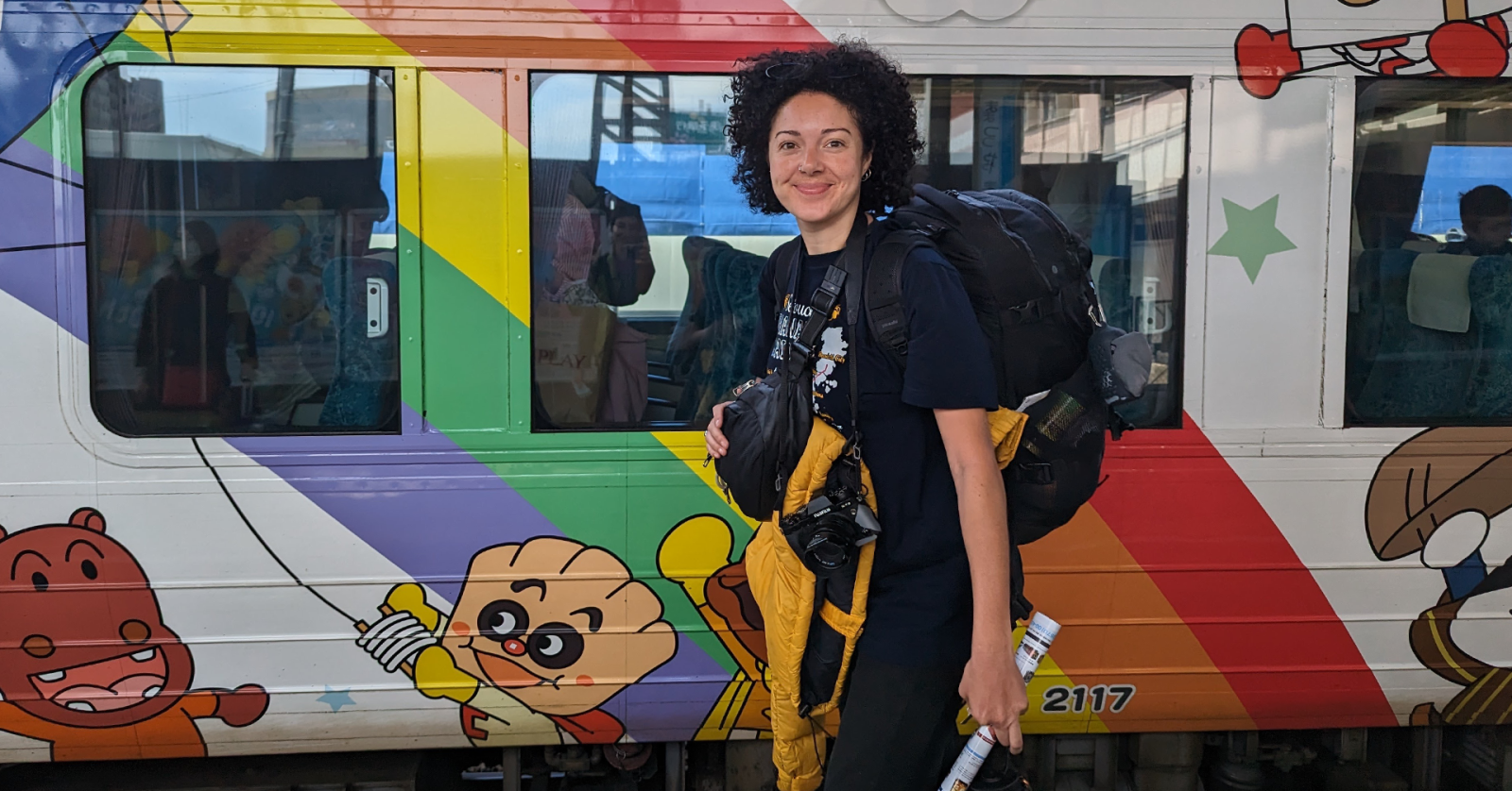 Lauren standing on a train platform with her carry on backpack